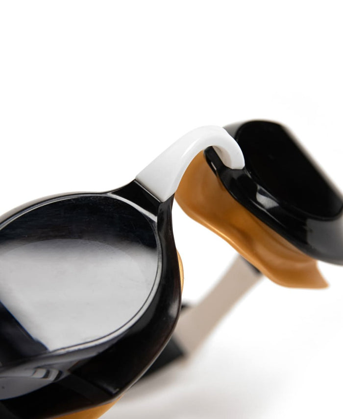 Arena Cobra Edge Swipe racing goggles in smoke, white, and gold with adjustable strap and aerodynamic design.