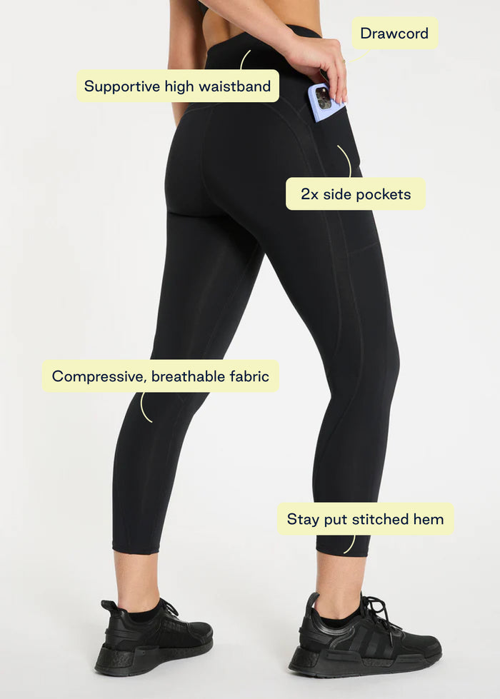Model wearing navy leggings and black long sleeve top for cool-weather workouts