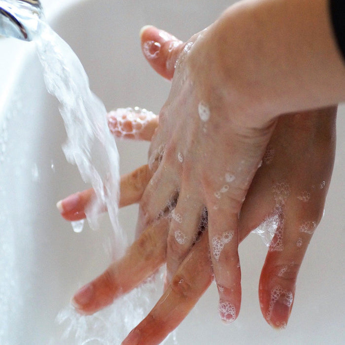 Person washing their hands using Superbug liquid travel soap