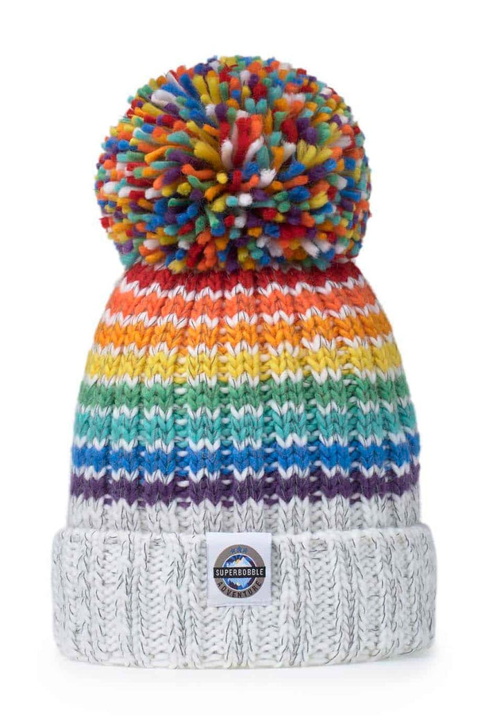 Swimzi Glacier Rainbow Super Bobble Hat, colorful knit hat with rainbow pattern and large bobble, perfect for cold weather.