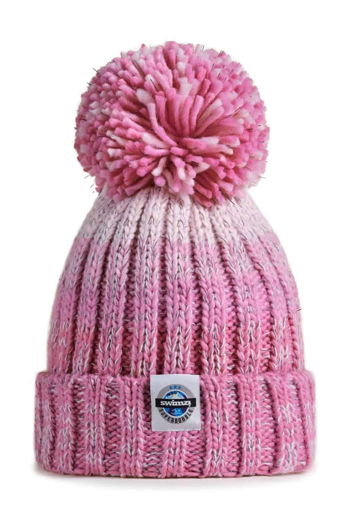 Pink Swimzi Rose Pinks Gradient Super Bobble Hat, a cozy knit cap with a large fluffy pom-pom for stylish winter wear.