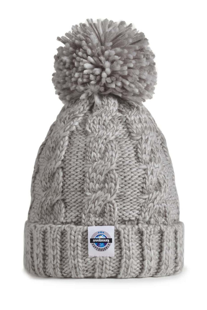 Swimzi Silver Grey Cable Knit Super Bobble Hat featuring a cozy, textured knit design and large pom-pom on top.