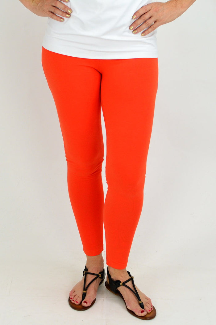 Orange ankle-length leggings from David Jessie, showing close-up of fitted, stretchy fabric and sleek design.