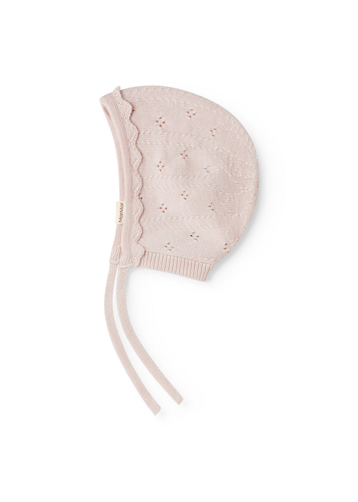 Axa sweater in misty pink with ribbed edge, hole pattern, and two drawstrings.