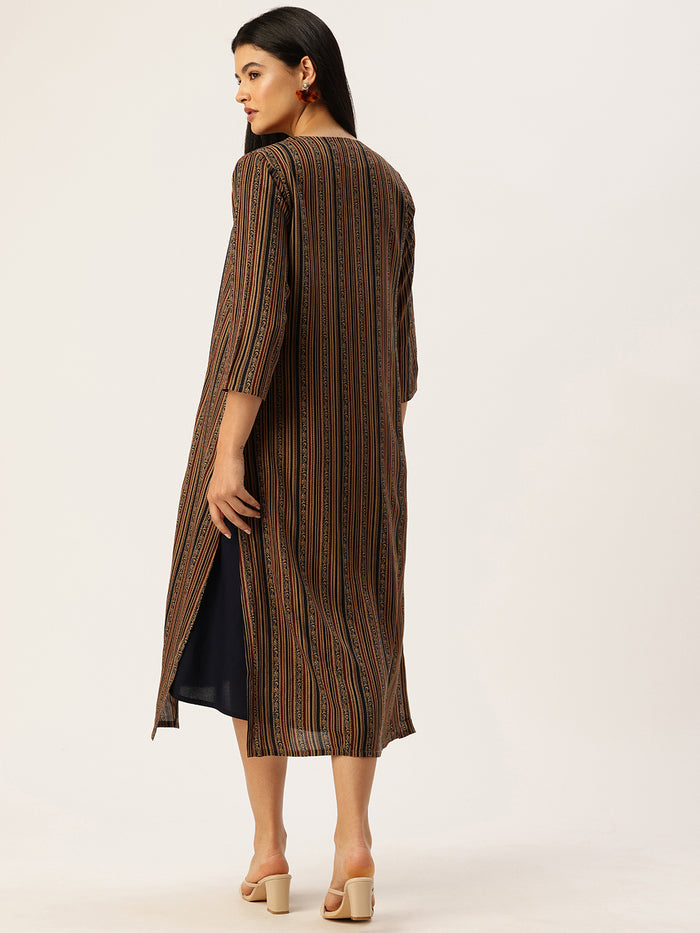 Woman wearing a navy dress with a patterned cardigan in a neutral setting , Beige Striped Printed Dress ,midi dress, dress, women’s western wear, party wear dress, casual wear dress