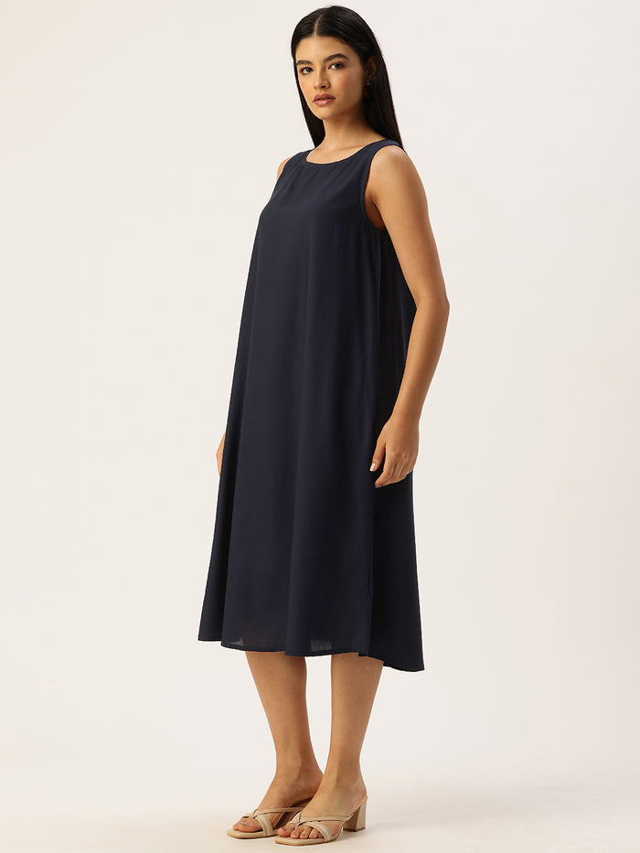 Woman wearing a navy dress with a patterned cardigan in a neutral setting , Beige Striped Printed Dress ,midi dress, dress, women’s western wear, party wear dress, casual wear dress