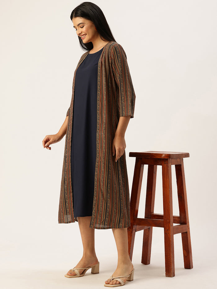 Woman wearing a navy dress with a patterned cardigan in a neutral setting , Beige Striped Printed Dress ,midi dress, dress, women’s western wear, party wear dress, casual wear dress