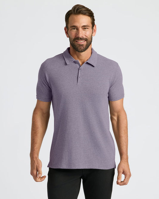 Man wearing Dark Heather Amethyst Short Sleeve Polo, smiling slightly.