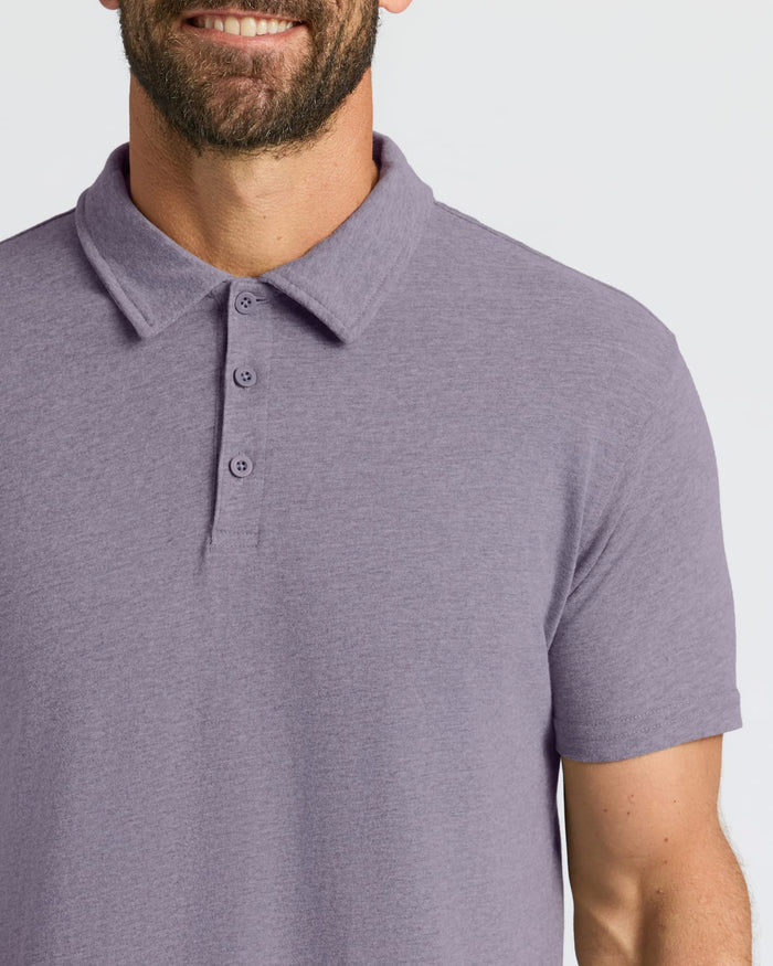 Man wearing Dark Heather Amethyst Short Sleeve Polo, smiling, showcasing its fit.