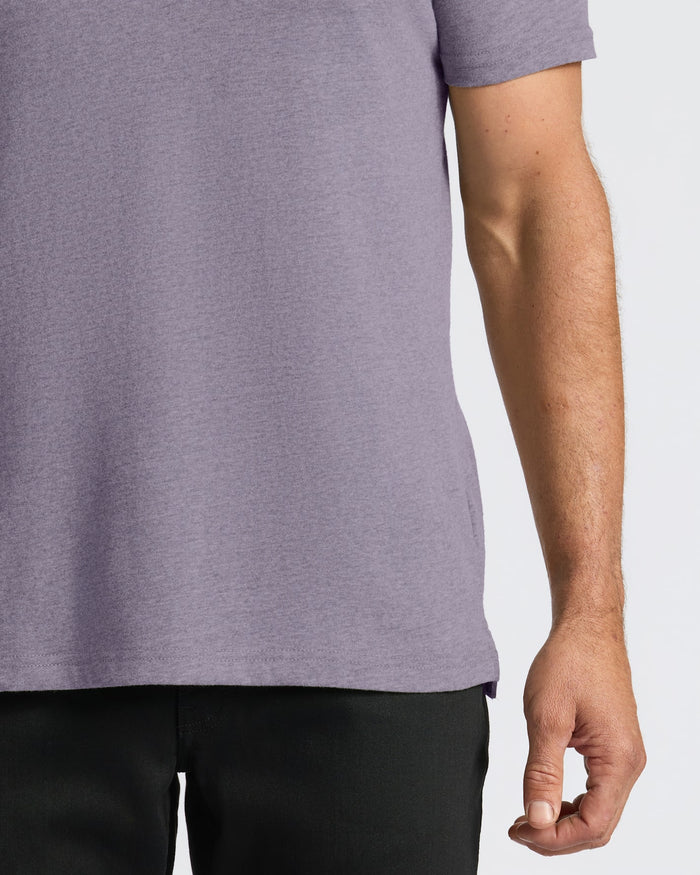 Person wearing a Dark Heather Amethyst Short Sleeve Polo with a fitted cut.