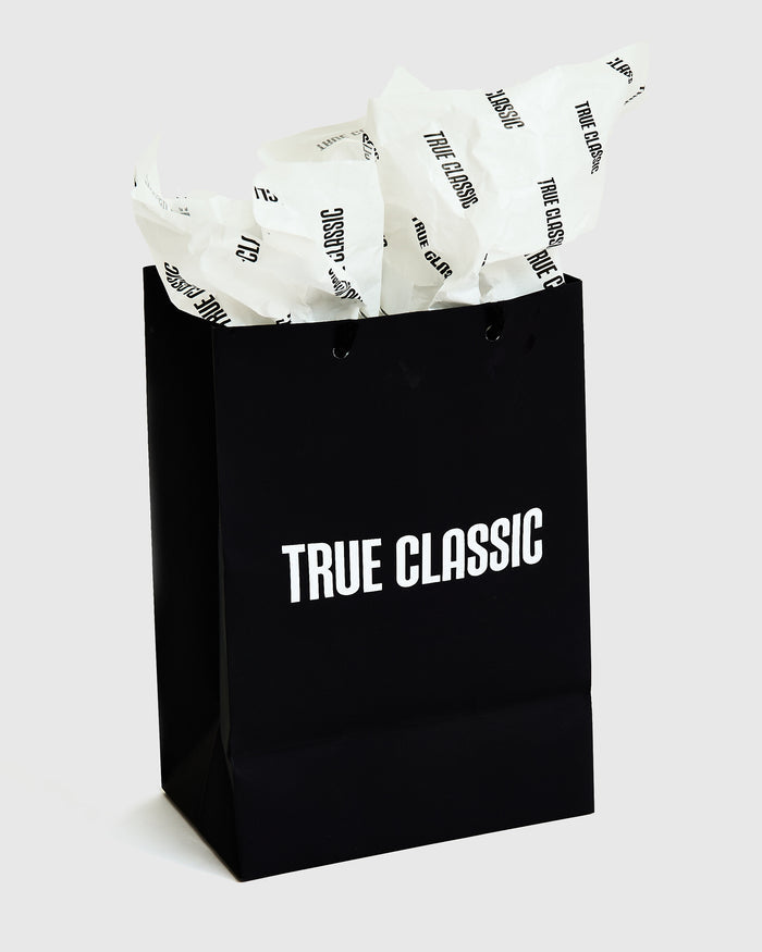 Gift Bag with TRUE CLASSIC logo and tissue paper.