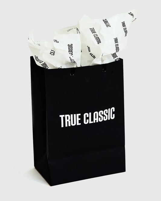 Gift Bag with TRUE CLASSIC logo and tissue paper.