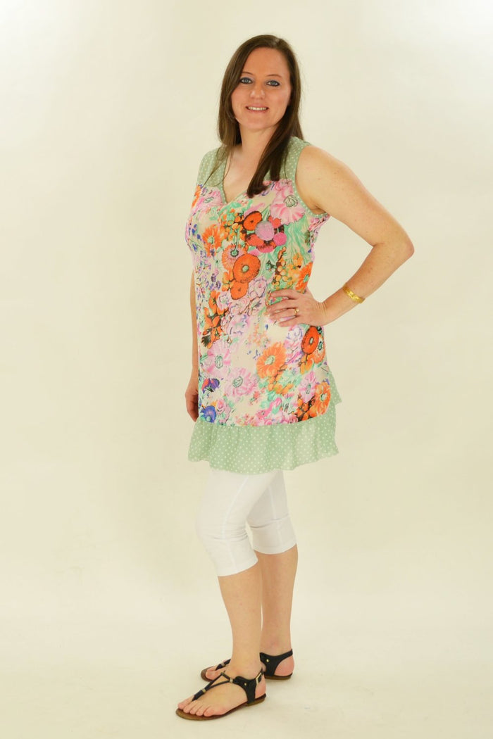 Orange Meadow Flowers Tunic by Whispers featuring a vibrant floral pattern and relaxed fit, displayed on a hanger.