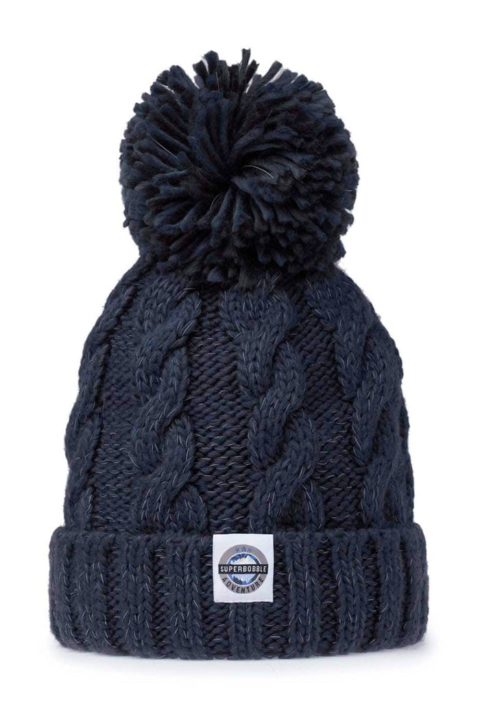 Swimzi Deep Navy Cable Super Bobble Hat in blue, a warm knit hat with a large bobble and cable pattern, designed for cold weather.